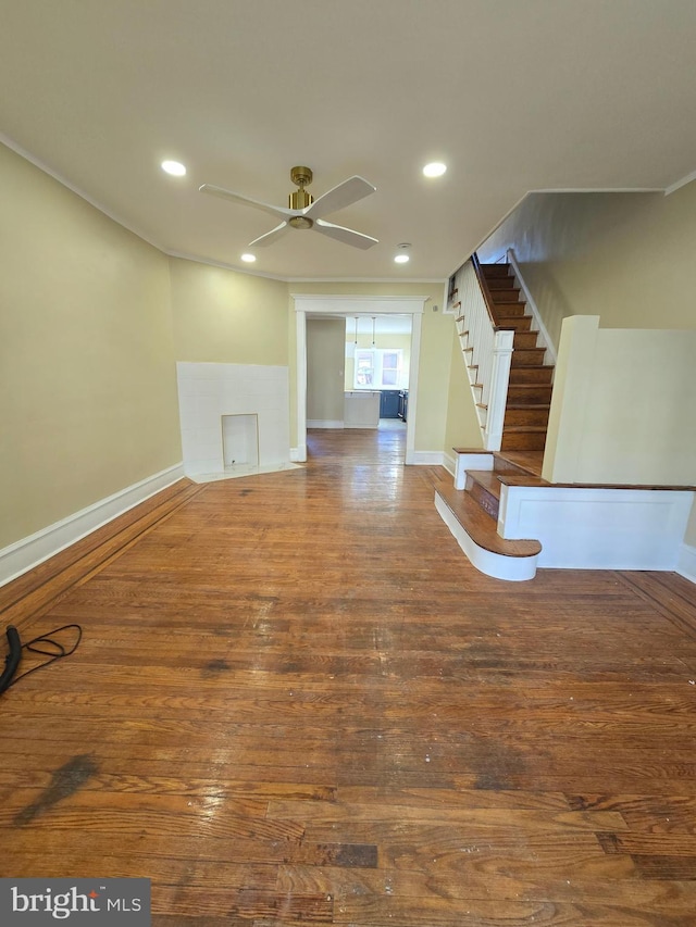 unfurnished living room with dark hardwood / wood-style flooring and ceiling fan