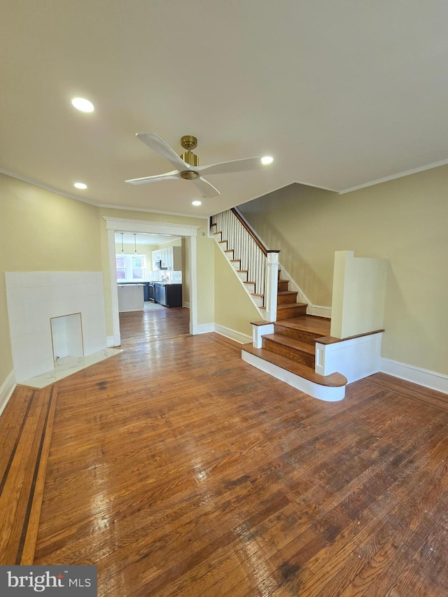 interior space featuring wood-type flooring, ornamental molding, and ceiling fan