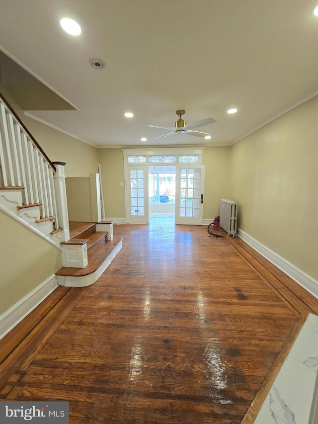 interior space featuring ornamental molding, wood-type flooring, radiator, and ceiling fan