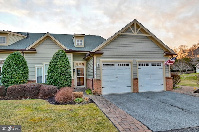 craftsman-style house with a garage and a lawn