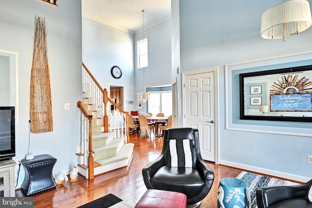 interior space featuring hardwood / wood-style flooring, crown molding, and a towering ceiling