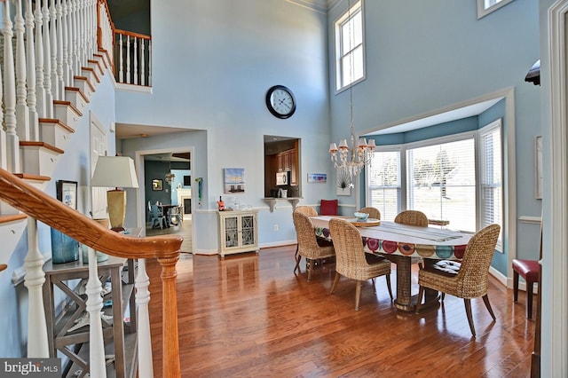 dining area featuring an inviting chandelier, hardwood / wood-style flooring, and a healthy amount of sunlight