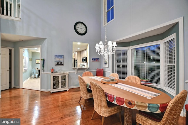 dining room featuring a chandelier, hardwood / wood-style floors, and a high ceiling