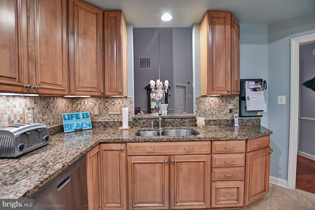 kitchen with sink, dark stone countertops, backsplash, and light tile patterned floors