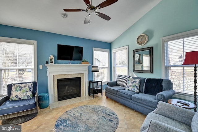 tiled living room featuring ceiling fan, vaulted ceiling, and a healthy amount of sunlight