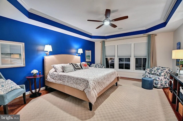 bedroom featuring crown molding, ceiling fan, a tray ceiling, and hardwood / wood-style flooring