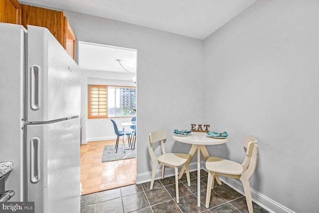 dining space featuring dark tile patterned floors