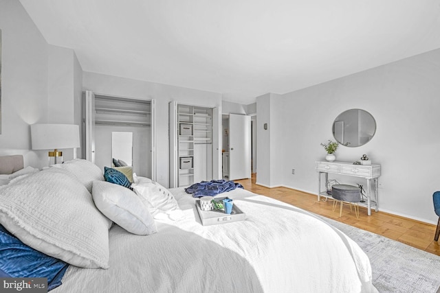 bedroom featuring hardwood / wood-style flooring and multiple closets