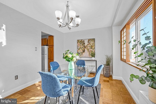 dining room featuring light parquet floors and an inviting chandelier