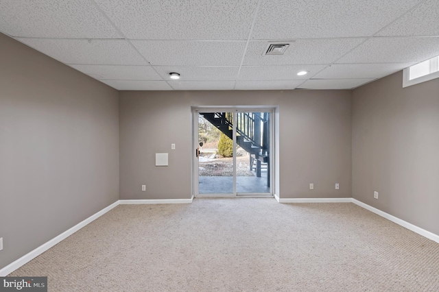 unfurnished room with a paneled ceiling and carpet