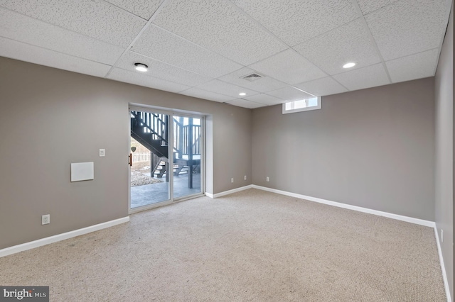 carpeted spare room with a paneled ceiling and a healthy amount of sunlight