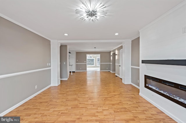 unfurnished living room with ornamental molding, an inviting chandelier, and light hardwood / wood-style floors