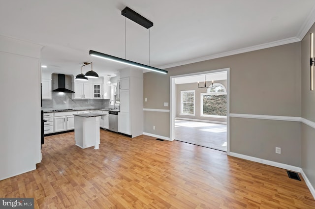 kitchen featuring pendant lighting, black gas cooktop, dishwasher, white cabinets, and wall chimney range hood