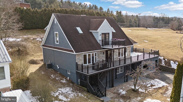 rear view of property with cooling unit, a balcony, and a deck