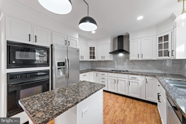 kitchen with wall chimney range hood, white cabinets, and black appliances