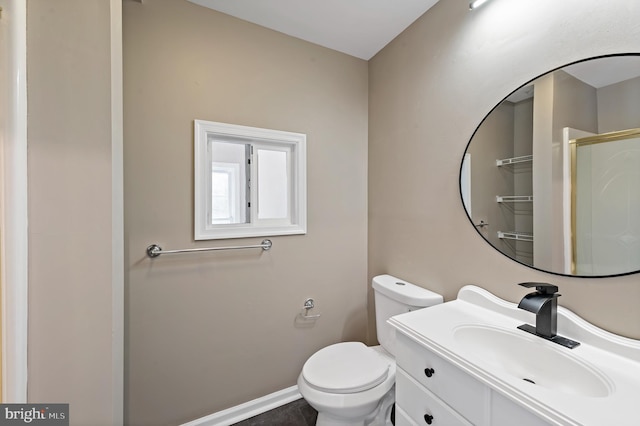 bathroom with a shower with door, vanity, and toilet