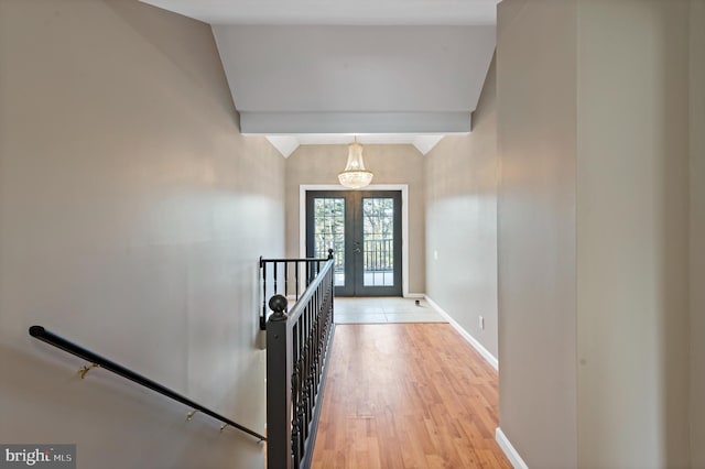 entryway featuring vaulted ceiling, light hardwood / wood-style flooring, and french doors