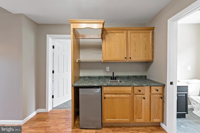 kitchen with sink, light hardwood / wood-style floors, and refrigerator