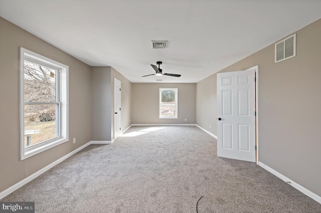 empty room with ceiling fan and light carpet