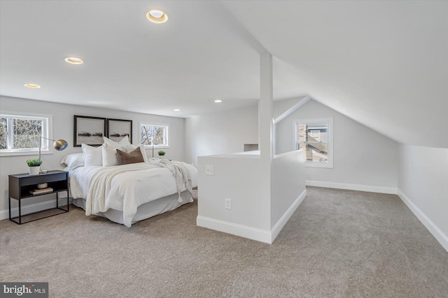 bedroom featuring multiple windows, vaulted ceiling, and light carpet