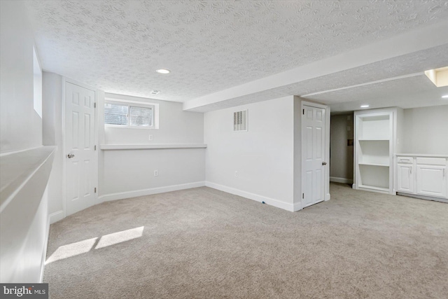 basement with light carpet and a textured ceiling