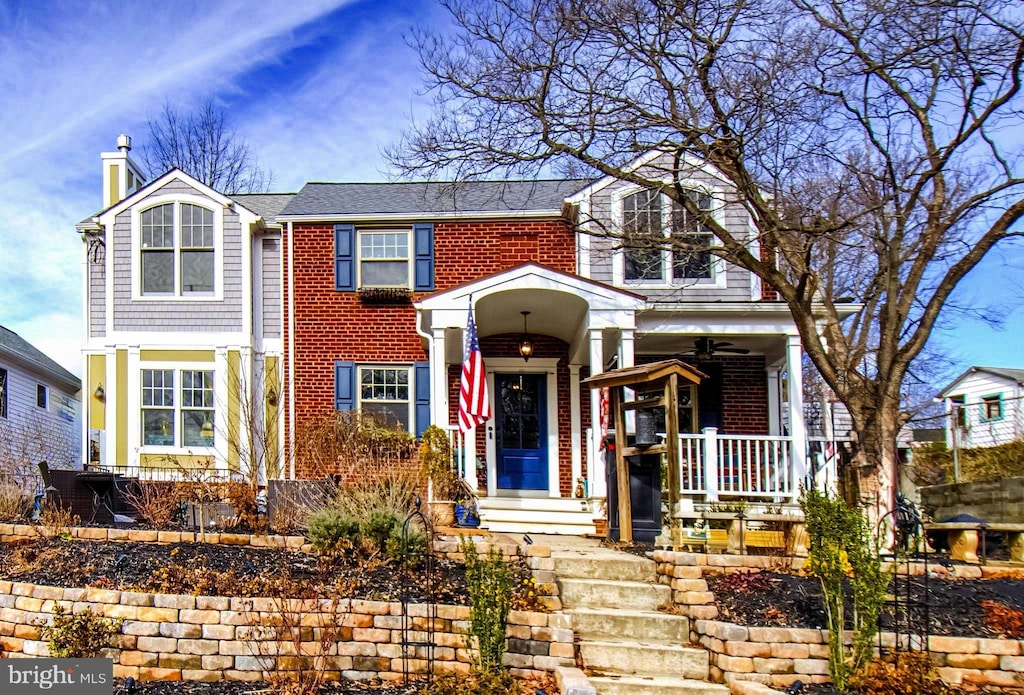 view of front of property with brick siding, a porch, and a chimney