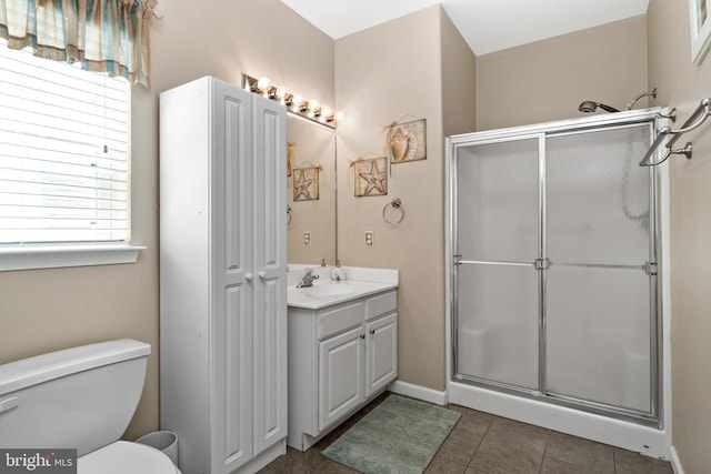 bathroom with walk in shower, vanity, toilet, and tile patterned flooring