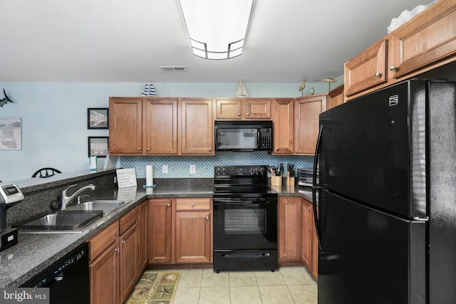 kitchen featuring tasteful backsplash, light tile patterned floors, black appliances, and sink