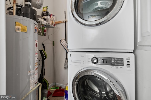 laundry area with stacked washer / dryer and water heater