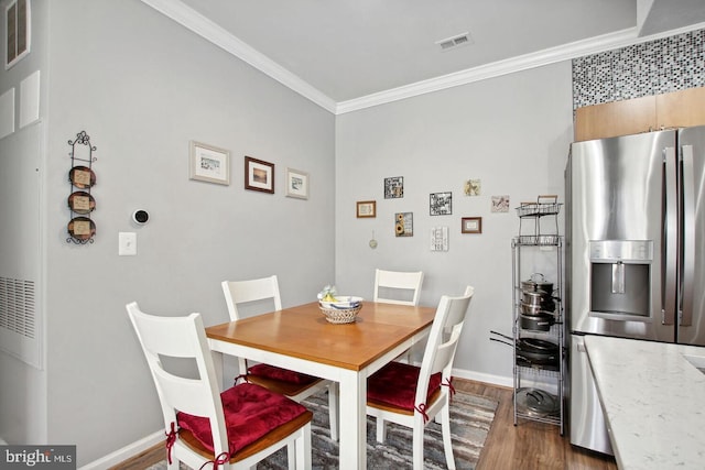 dining space with crown molding and dark hardwood / wood-style flooring