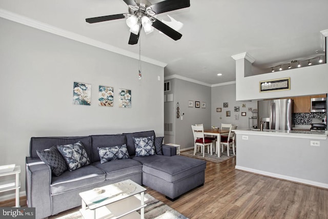 living room with hardwood / wood-style floors, ornamental molding, and ceiling fan