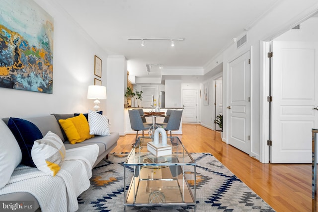 living room with light hardwood / wood-style flooring and ornamental molding