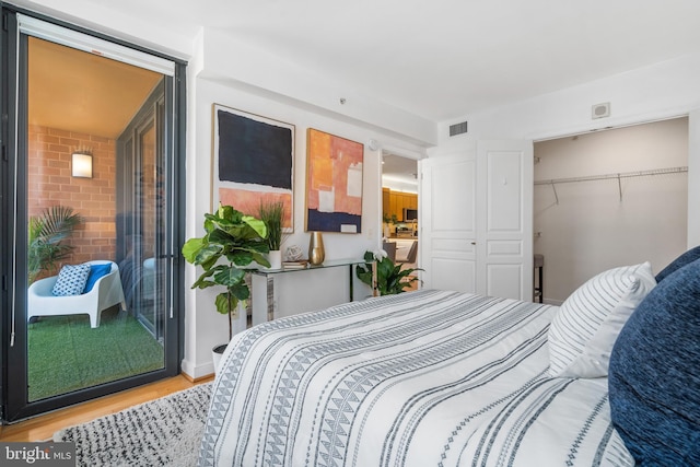 bedroom with light hardwood / wood-style floors and a closet