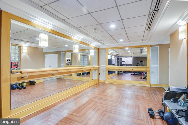 exercise area featuring crown molding, parquet flooring, and a drop ceiling