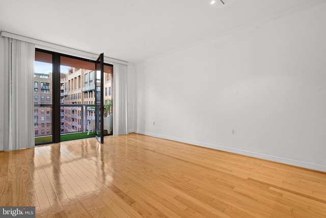 unfurnished room featuring wood-type flooring and expansive windows