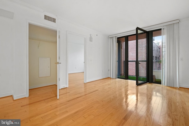 spare room with expansive windows and hardwood / wood-style flooring