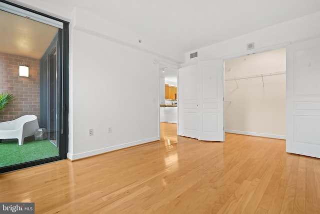 unfurnished bedroom with light hardwood / wood-style floors and a closet