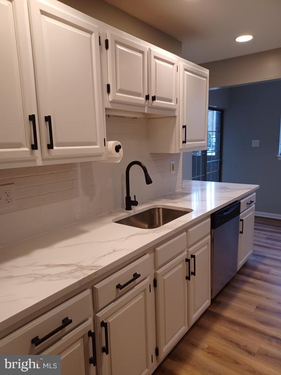 kitchen featuring white cabinetry, sink, light stone counters, and dishwasher