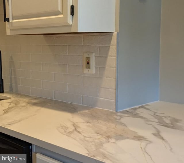 details featuring white cabinets and a wood stove