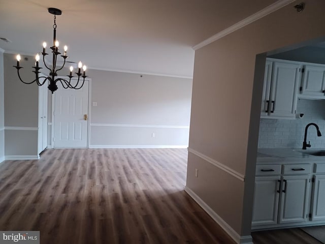 unfurnished dining area with sink, ornamental molding, and hardwood / wood-style floors