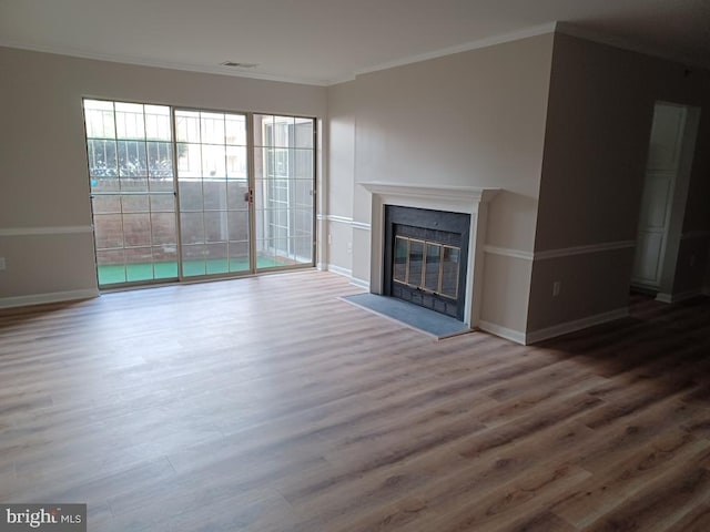 unfurnished living room with wood-type flooring and crown molding