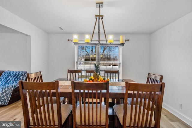 dining room with an inviting chandelier and light wood-type flooring