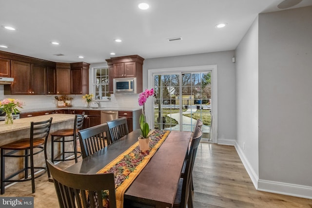 dining room with sink and light hardwood / wood-style flooring