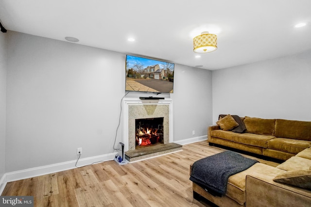 living room featuring a high end fireplace and hardwood / wood-style floors