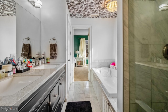 bathroom with vanity and tiled bath