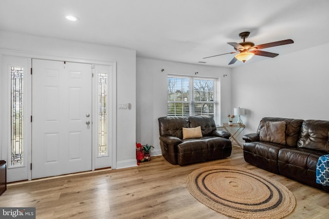 living room featuring light hardwood / wood-style floors and ceiling fan