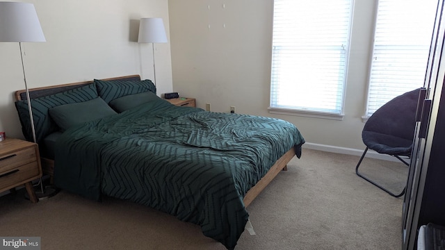 bedroom featuring light carpet and baseboards