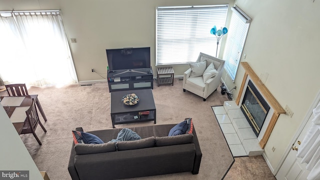 carpeted living room with plenty of natural light, a fireplace, and baseboards