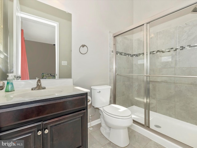 bathroom featuring toilet, vanity, baseboards, tile patterned floors, and a stall shower