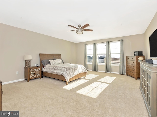 bedroom featuring a ceiling fan, light colored carpet, and baseboards